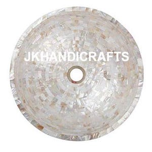May include: Round, white mosaic sink with a central drain hole. The sink is made of small, irregularly shaped pieces, creating a textured surface. The text "JKHANDICRAFTS" is displayed across the center of the sink.