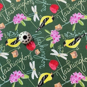 May include: A green fabric with a repeating pattern of yellow birds, red apples, pink flowers, dragonflies, and the text "Washington".