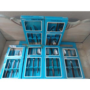 May include: Six blue cardboard boxes containing Ekco Eterna stainless tableware with brown handles. Each box features cutouts displaying forks, spoons, and knives. The packaging includes the text Ekco Eterna Stainless Tableware and Custom Designed.