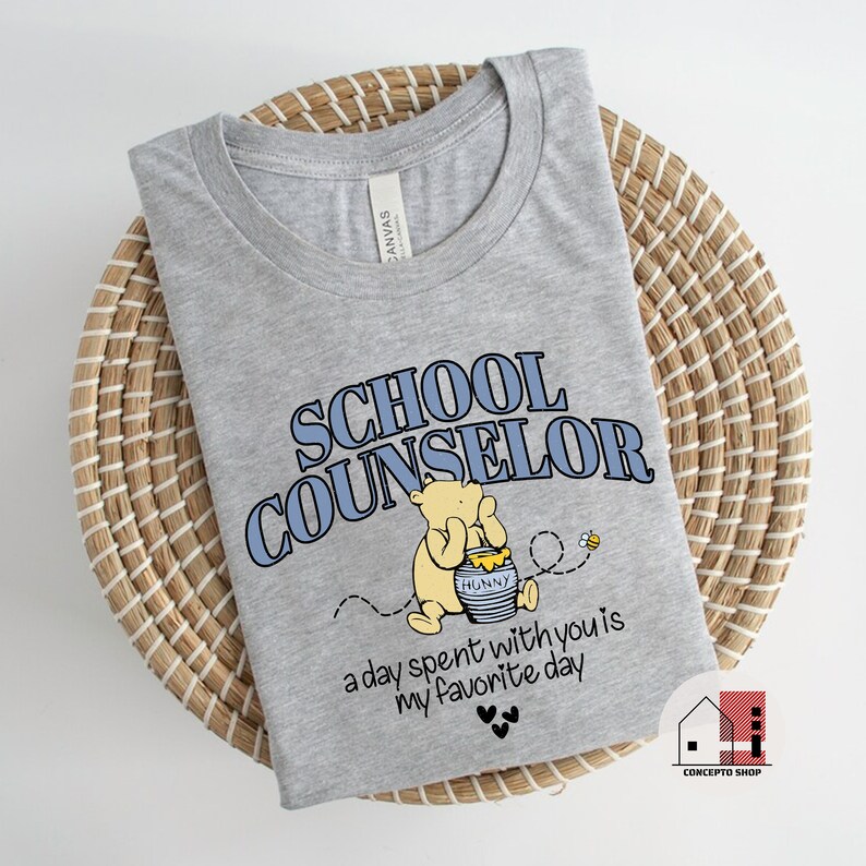 May include: Gray t-shirt with a Winnie the Pooh illustration and the text "School Counselor" in blue. The text "a day spent with you is my favorite day" is printed below the illustration.