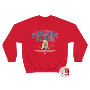 May include: Red sweatshirt with a Winnie the Pooh illustration and the text "Pediatric Nurse" in blue and white. The text below the illustration reads "Sometimes, the smallest things take up the most room in your heart."