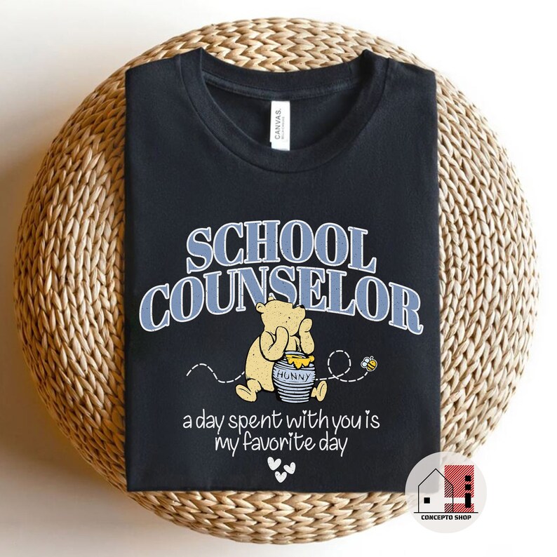 May include: Black t-shirt with a blue and white graphic of Winnie the Pooh holding a honey pot. The text "SCHOOL COUNSELOR" is above the graphic and the text "a day spent with you is my favorite day" is below the graphic.