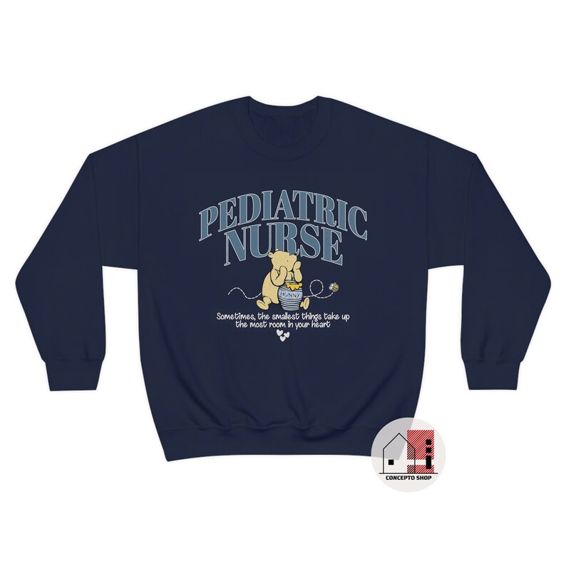 May include: Navy blue sweatshirt with a Winnie the Pooh illustration and the text "Pediatric Nurse" in a blue and white arched font. The text below the illustration reads "Sometimes, the smallest things take up the most room in your heart."