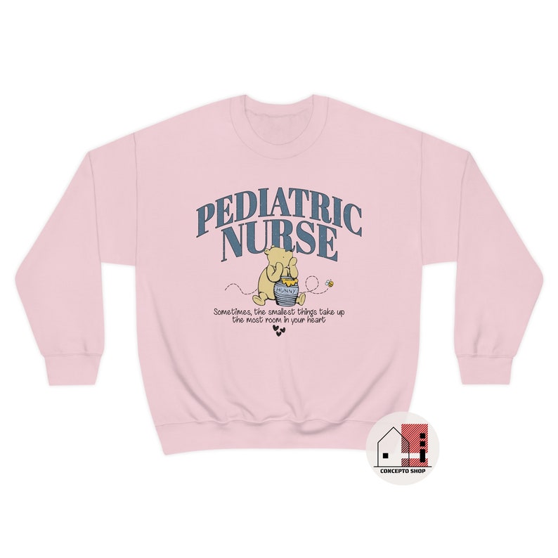May include: Pink sweatshirt with a graphic of Winnie the Pooh holding a honey pot. The text "PEDIATRIC NURSE" is above the graphic and the text "Sometimes, the smallest things take up the most room in your heart" is below the graphic.