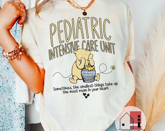 May include: A white t-shirt with a Winnie the Pooh illustration and the text "Pediatric Intensive Care Unit" and "Sometimes, the smallest things take up the most room in your heart".