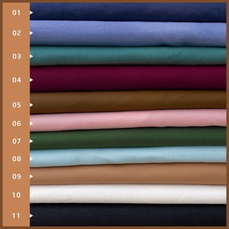 K&ouml;nnte beinhalten: Ein Stapel von elf Stoffmustern in verschiedenen Farben, darunter Marineblau, Hellblau, T&uuml;rkis, Burgunderrot, Braun, Rosa, Waldgr&uuml;n, Hellblau, Beige, Wei&szlig; und Schwarz.