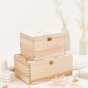 Two natural wooden boxes are presented in the picture on top of each other. The bottom box represents the larger size L and the smaller box represents the smaller size S.