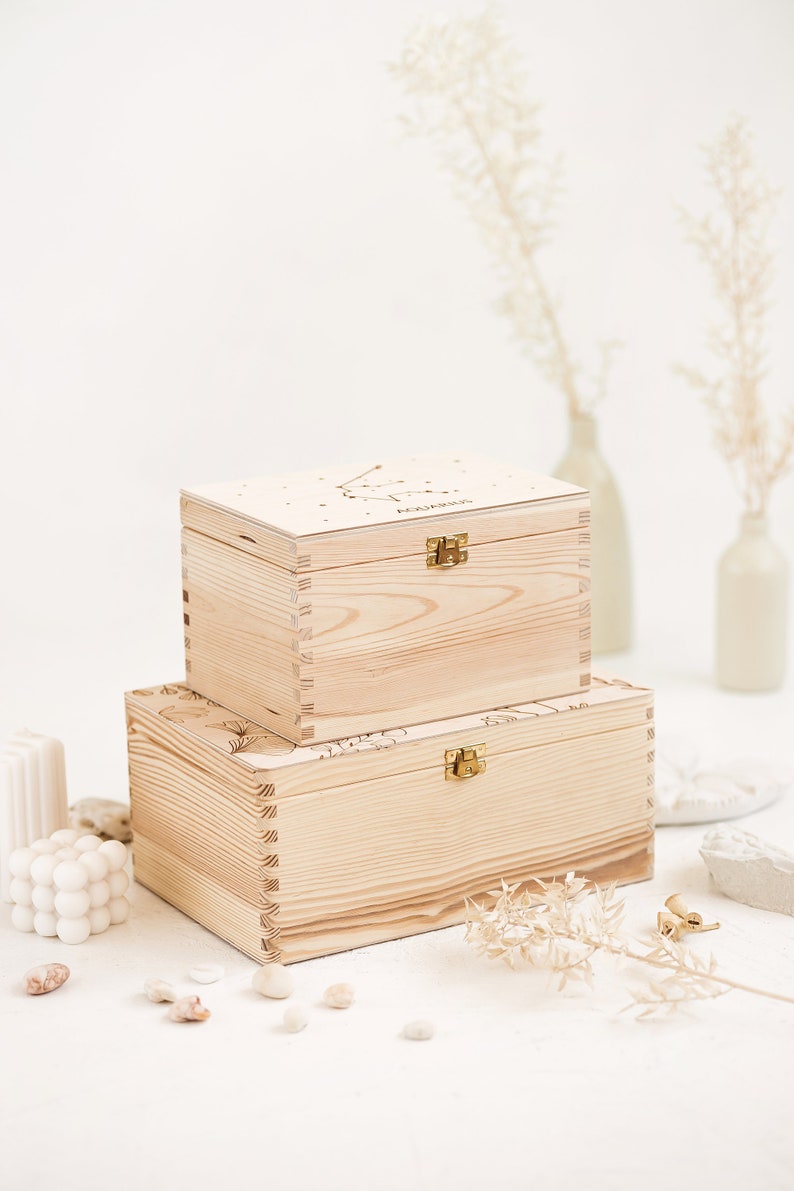 Two natural wooden boxes are presented in the picture on top of each other. The bottom box represents the larger size L and the smaller box represents the smaller size S.