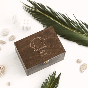 Wooden dark brown box with subtle design of dog ears which will feature the name and the dates of your beloved dog, The box is created to store the items the leash, toys and other items which remind you of the best times spent together.