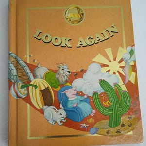 May include: A colorful book cover with the title "LOOK AGAIN" in yellow letters. The cover features a variety of animals and objects, including a goat, a pig, a rabbit, a cactus, a pumpkin, and a sun.