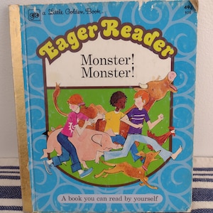 May include: A blue and green book cover with the title "Eager Reader" in yellow letters. The book cover features a cartoon illustration of children running away from a cow, pig, and dog. The text "Monster! Monster!" is printed in black letters. The book is a "Little Golden Book" and has a price of 49 cents.