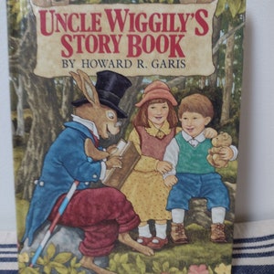 May include: A vintage children's book titled "Uncle Wiggily's Story Book" by Howard R. Garis. The cover features a cartoon rabbit wearing a top hat and blue jacket, reading a book to two children.