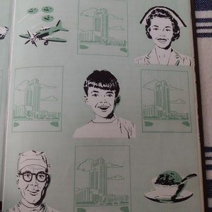 Op de afbeelding: Een vintage boek met illustraties van een gebouw, een vliegtuig, een verpleegster, een jongen, een man met een bril en een kom ijs. Het boek heeft een groene kaft met witte illustraties.