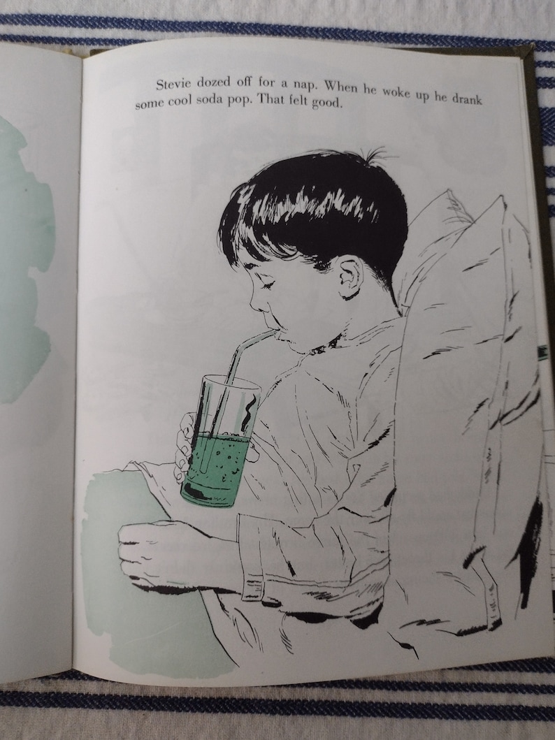Op de afbeelding: Een zwart-witte illustratie van een jonge jongen die in bed zit en een groene frisdrank drinkt met een rietje. De tekst in de afbeelding luidt: "Stevie dozed off for a nap. When he woke up he drank some cool soda pop. That felt good."