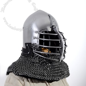 May include: A silver helmet with a cage-like face mask and a chainmail coif. The helmet is made of metal and has a rounded shape. The face mask is made of metal bars and has a pointed shape. The chainmail coif is made of metal rings and covers the neck and shoulders.