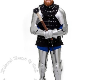 May include: A full suit of silver plated armor with a black leather jerkin and studded leather straps. The armor includes a helmet, gauntlets, and greaves. The person is holding a wooden staff.