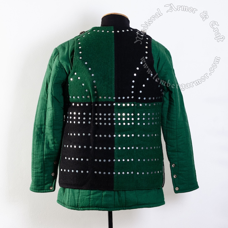 May include: A green and black padded jacket with silver metal studs. The jacket is quilted and has a long sleeve design.