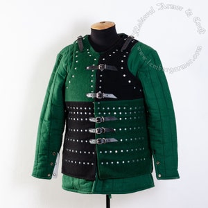 May include: A green and black padded armor with straps and buckles. The armor is made of quilted fabric and has a studded design. The armor is displayed on a mannequin.