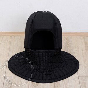 May include: Black padded medieval coif with a wide, rounded collar. The coif is made of quilted fabric and has a pointed top.