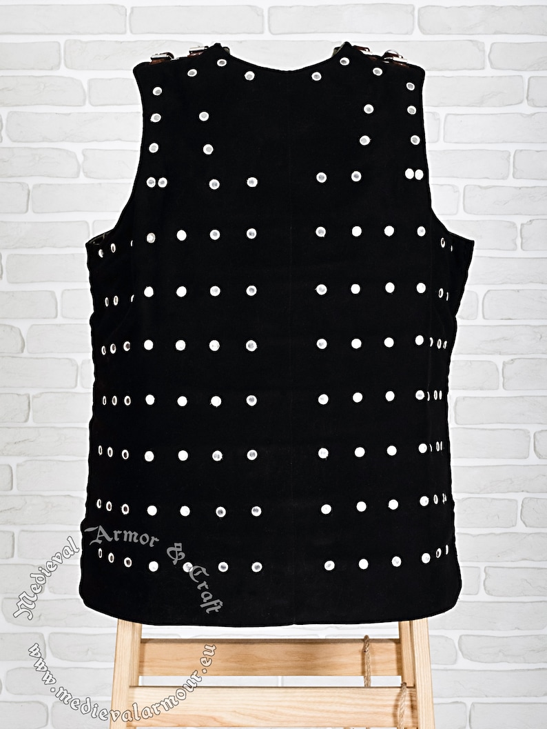 May include: Black leather vest with silver studs, featuring the text "Medieval Armor & Craft" and the website address "www.medievalarmour.eu".