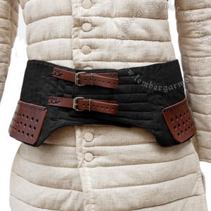 May include: A black padded belt with two brown leather straps and buckles. The belt has two brown leather side panels with a perforated design. The belt is worn over a beige quilted garment.
