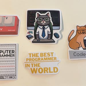 Peut inclure: Un ensemble de cinq autocollants en vinyle sur le th&egrave;me de la programmation. Les motifs incluent des touches de clavier rouges marqu&eacute;es Junior Dev, un chat &agrave; lunettes devant un ordinateur, un code binaire avec le texte COMPUTER PROGRAMMER, un autocollant jaune indiquant THE BEST PROGRAMMER IN THE WORLD, et un chat orange avec un ordinateur portable marqu&eacute; Code Cat.