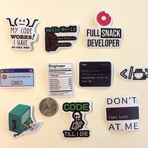 Peut inclure: Un ensemble de onze autocollants en vinyle avec des graphismes et du texte sur le th&egrave;me de la programmation, incluant des phrases comme My Code Works, Full Snack Developer et Don't Caps Lock At Me, pr&eacute;sent&eacute;s avec une pi&egrave;ce pour l'&eacute;chelle.