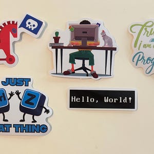 Peut inclure: Un ensemble de cinq autocollants en vinyle avec des motifs informatiques : un cheval de Troie rouge avec un drapeau t&ecirc;te de mort, une personne &agrave; un bureau avec un ordinateur et un chat, le texte Trust me I am a Programmer, deux touches de clavier ctrl et Z, et une &eacute;tiquette noire avec le texte Hello, World!.