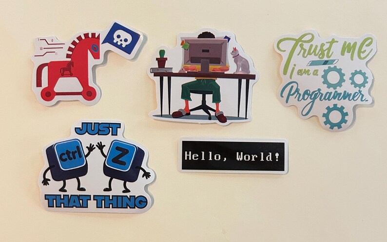Peut inclure: Un ensemble de cinq autocollants en vinyle avec des motifs informatiques : un cheval de Troie rouge avec un drapeau t&ecirc;te de mort, une personne &agrave; un bureau avec un ordinateur et un chat, le texte Trust me I am a Programmer, deux touches de clavier ctrl et Z, et une &eacute;tiquette noire avec le texte Hello, World!.