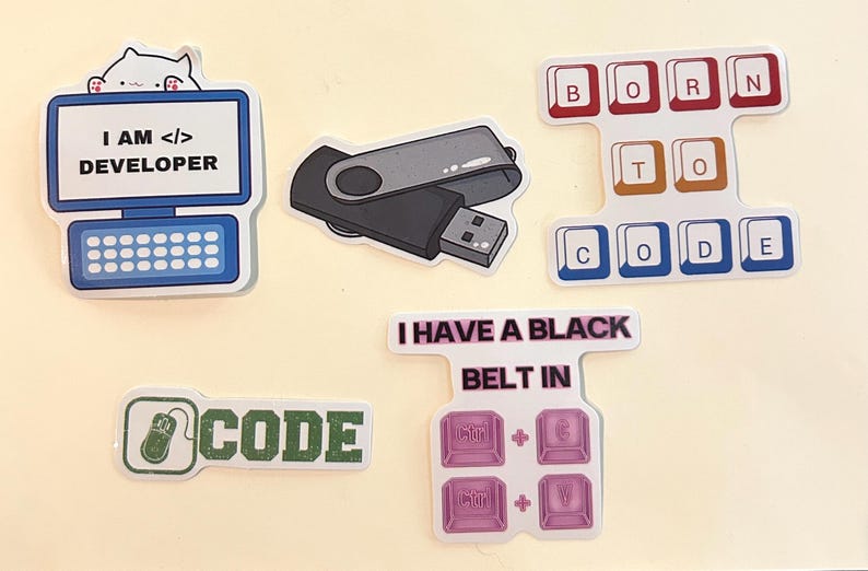 Peut inclure: Un ensemble de cinq autocollants en vinyle avec des motifs technologiques. On y voit un ordinateur avec un chat et le texte I AM DEVELOPER, une cl&eacute; USB, des touches de clavier BORN TO CODE, une ic&ocirc;ne de souris avec le mot CODE et un raccourci clavier.