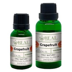 May include: Two green glass bottles of grapefruit essential oil with black lids and white labels. The labels have the text "H.E.A.L. Healthy Energy Amazing Life" and "Grapefruit Pure Essential Oil". The smaller bottle is labeled "0.50Z/15ML" and the larger bottle is labeled "1OZ/30ML". Both bottles have the text "Only Nature! No Additives, Fillers, or Synthetics".