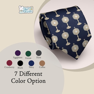 May include: A navy blue necktie featuring a repeating pattern of gold-colored monstrances. The image includes a logo for Rabbit Patch Gifts and a color chart displaying seven different color options labeled Eggplant, Forest, Slate, Cranberry, Black, Navy, and Coffee, with the text 7 Different Color Option.