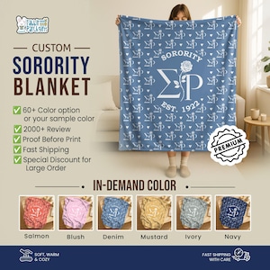 Puede incluir: Una manta de hermandad personalizada en azul denim, con un diseño ΣΡ blanco y un patrón de rosas y corazones. La manta tiene el texto "SORORITY" y "EST. 1922". Disponible en varios colores, incluyendo Salmón, Blush, Mostaza, Marfil y Marino.