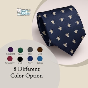 Puede incluir: Corbata azul marino con un patrón repetido de pequeñas tortugas marinas de color beige claro. La corbata está doblada, mostrando su diseño. La imagen también muestra una paleta de colores con ocho opciones diferentes.