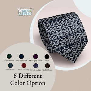 May include: A black necktie featuring a white periodic table of elements print. The design displays various chemical symbols, atomic numbers, and names in a grid pattern. The image includes a logo with a rabbit and the text Rabbit Patch Gifts.
