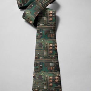 May include: A green and brown patterned necktie featuring a circuit board design. The tie is made of a smooth fabric and is suitable for tech enthusiasts or those who appreciate unique accessories. The tie is displayed against a white background.