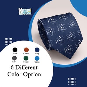 Peut inclure: Cravate bleu marine avec un motif d'atomes blancs. La cravate est présentée en biais, mettant en valeur le motif. L'image affiche également une palette de couleurs avec six options : noir, cuivre, marine, ardoise, forêt et océan. Le texte indique "6 Different Color Option."