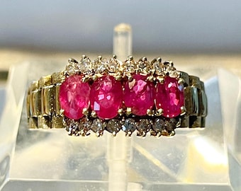 May include: A gold ring featuring four oval-shaped ruby gemstones set in a band of smaller diamonds.