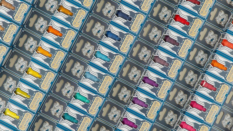 May include: A variety of colorful embroidery floss spools arranged in rows. Each spool is packaged in a blue and gold box with the word "VINTAGE" printed on it.