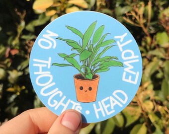 May include: A blue and white round sticker with a plant in a pot and the text "No Thoughts. Head Empty."