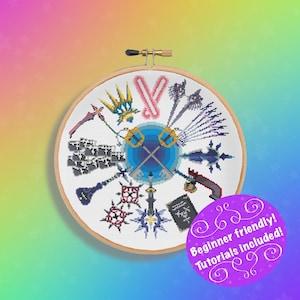 Op de afbeelding: Een kruissteekpatroon met verschillende Keyblades uit de Kingdom Hearts-videogameserie. De Keyblades zijn in een cirkel rond een blauw en wit symbool gerangschikt. Het patroon is ingelijst in een houten ring. Beginnersvriendelijk! Tutorials inbegrepen!