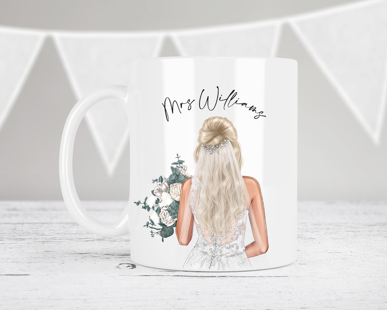May include: White ceramic mug with a bride illustration holding a bouquet of white flowers and greenery. The text "Mrs. Williams" is printed on the mug.