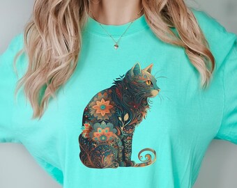 May include: A turquoise t-shirt with a colorful, floral patterned cat design.