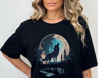 May include: Black t-shirt with a graphic of a wolf howling at the moon. The moon is blue and the wolf is black. The graphic is surrounded by trees and a reflection of the wolf in the water.