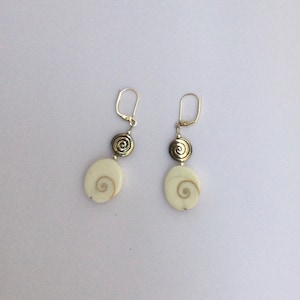 Könnte beinhalten: Ein Paar silberne Ohrringe mit weißen Muschel- und silbernen Spiralen-Akzenten.