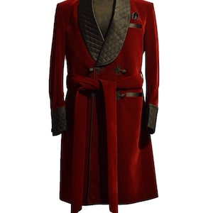 Puede incluir: Una bata larga de terciopelo rojo con un cuello de chal de satén negro y ribetes a juego. La bata tiene un cinturón de atar y dos bolsillos. La bata tiene borlas en la parte inferior.