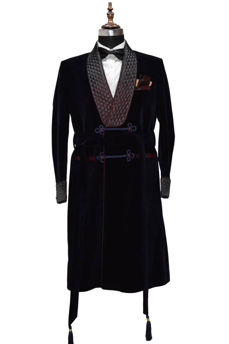 May include: A navy blue velvet robe with a black quilted shawl collar and a matching sash. The robe has a decorative knot detail on the sash and a tassel at the bottom.