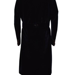 May include: A black velvet robe with a quilted collar and a matching belt. The robe has long sleeves and a tassel at the bottom of each side.