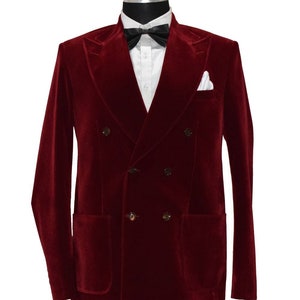 Op de afbeelding: Een dubbelrijig bordeauxrood fluwelen blazer met een zwarte strik en een wit zakdoekje.