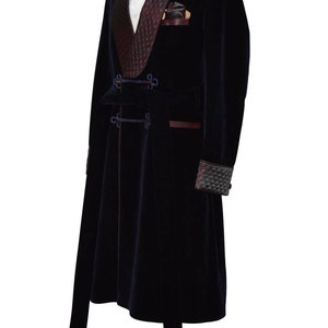 May include: A long, dark blue velvet robe with a burgundy velvet shawl collar and a black bow tie. The robe has a sash with gold buckles and tassels.